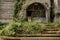 Weedy stairway before run-down entrance of abandoned 1960s` building