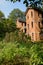 Weedy vegetable field before abandoned red brick apartment buildings