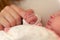 Week old baby holding mother`s finger