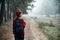 Weekend breaks and getaways in forests. Stay close to nature. Young woman in red hat and sweater with backpack