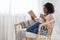 Weekend Pastime. Young Black Woman Relaxing In Armchair With Book And Coffee