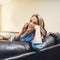 The weekends were made for catching up with loved ones. a relaxed young woman using a smartphone on the sofa at home.