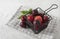 Weet fresh delicious red plums on black basket white wood table summer fruits