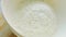 Weighing flour on a scale. Female hands pour flour from a paper bag into a transparent bowl of kitchen scales. Preparing