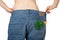 Weight loss and healthy eating or dieting concept. Slim girl in oversized jeans with a carrot, dill and parsley in the pocket
