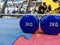Weight loss and strength increase in gym with a closeup of two blue 2 kg small dumbbells in a cool and modern well equipped gym