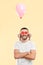 Weird funny man with small paper hearts by their eyes and pink air balloon on his neck