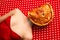 Weird people concept. Young girl lying on table with pizza on her face over red-white background. Vintage, retro style