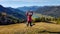 Weissensee - A woman jumping on a slope with the view on the distant lake