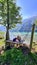 Weissensee - Woman relaxing on wooden swing with scenic view of alpine landscape at east bank of lake Weissensee