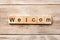 Welcom word written on wood block. welcom text on table, concept