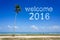 Welcome 2016 word cloud in blue sky at tropical beach
