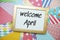 Welcome April text on colorful background