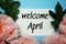 Welcome April typography text with peony flowers on blue background
