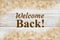 Welcome Back message with gold triangles swirl