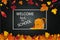 Welcome Back to school concept. School backpack, autumn september leaves on school chalkboard, blackboard background