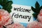 Welcome February typography text with peony flowers on blue background