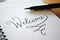 WELCOME hand-lettered in notebook