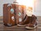 Welcome home, homecoming, travel and tourism concept. Vintage suitcase with old boots  in front of open door