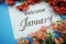 Welcome January text with Pink Flower frame on blue background