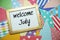 Welcome July text on colorful background