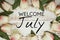 Welcome July text and tulip flower decoration on wooden background