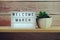 Welcome March word in light box on wooden shelves background