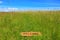 Welcome mat in a grass meadow with blue sky