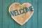 Welcome message wooden heart on turquoise painted background
