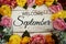 Welcome September text and Flowers Colorful Border Frame on wooden background