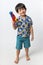 Welcome Thailand Songkran festival, Portrait of Asian boy wearing flower shirt smiled with water gun on white background