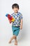 Welcome Thailand Songkran festival, Portrait of Asian boy wearing flower shirt smiled with water gun on white background