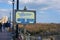 Welcome to the Atlantic City Boardwalk sign with a wooden frame on the boardwalk near a sand dune covered with brown tall grass