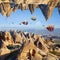 Welcome to Cappadocia concept. Fantastic unreal turned upside down landscape. Hot air balloons fly in clear morning sky near