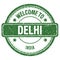 WELCOME TO DELHI - INDIA, words written on green stamp