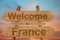 Welcome to France sing on wood background