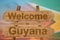 Welcome to Guyana sing on wood background with blending national flag