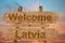 Welcome to Latvia sign on wood background