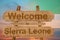 Welcome to Sierra Leone sign on wood background with blending national flag