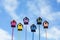 Welcome to the spring garden birds to a group of colorful wooden birdhouses on a blue sky background
