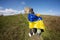 Welcome to Ukraine. Two brothers hold ukrainian flag near big stone in hill Pidkamin