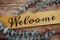 Welcome typography text and artificial eucalyptus decorate on wooden background