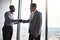 Welcoming him to the company. two corporate businessmen shaking hands during a meeting in the boardroom.