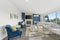 Welcoming living room with a blue accent wall, white faux fur pillows and a modern fireplace