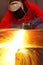 Welder bends to cut metal beam with orange sparks.