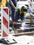 Welder construction workers working on city street crossroad, replacing old rotten tram rails with new once and arc welding them