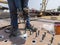 A welder is using a Stud Welding Machine to weld stud bolt on steel plate, at industrial factory