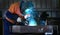 Welder at work up close to weld in maintenance workshop