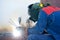 Welder at work. Welding steel sheets of the shell of the reservoir for filling with gasoline and petroleum products in the tank