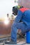 Welder at work. Welding steel sheets of the shell of the reservoir for filling with gasoline and petroleum products in the tank